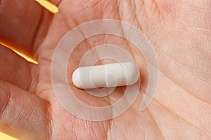 White pills and tablets in the woman. Macrophotography. Close-up. Medicine concept. Minimalistic abstract concept