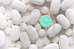 White pills on a white background. One bright blue round pill accent.