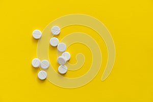 White pills on yellow background. Medicine, medication, painkillers, tablet, medicaments, drugs, antibiotic, vitamin