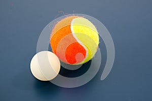 White ping pong ball and tennis ball