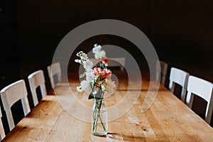 white and pink Flowers and roses on a wooden table in Minimalism table with low light and black background