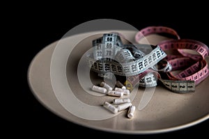 measuring tapes with pills on a gray plate