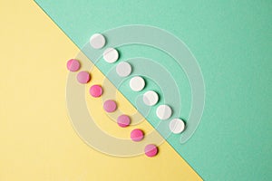 White and pink medicines on a colored background