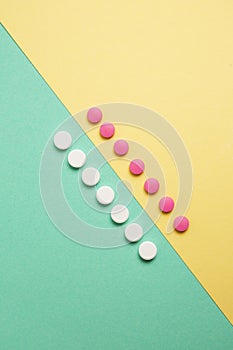 White and pink medicines on a colored background