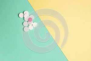 White and pink medicines on a colored background