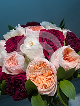 White pink and red roses in a bouquet with leaves