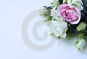 White and pink roses in a delicate bouquet on a light background. Festive flower arrangement.