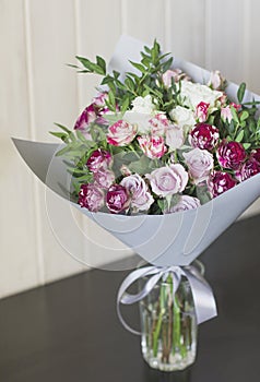 The bouquet of white and pink spray roses in gray floral paper