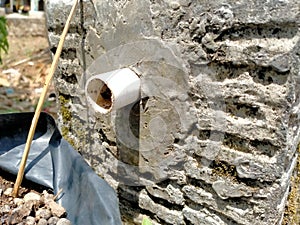 The white pipeline shower is occurring on the wall cement surface of pond