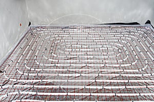 White pipes of underfloor heating systems, distributed in an individual family house on insulating foil.