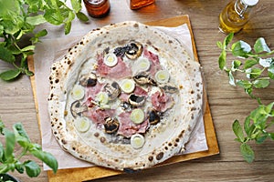 White pizza with leek, mushrooms, ham and cheese, on a wooden cutting board, top view.