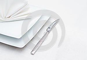 White place setting with knife and folded napkin