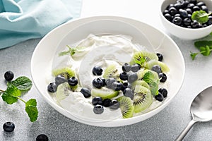 White plain greek yogurt with fresh blueberries and kiwi fruit