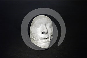 White plaster cast of a person on black background