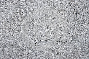 White plaster painted wall with curvy crack. Cracked wall closeup photo. Architecture detail background