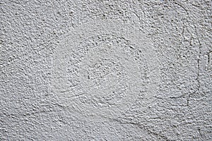 White plaster painted wall with grit and grain. Cracked wall closeup photo. Architecture detail background