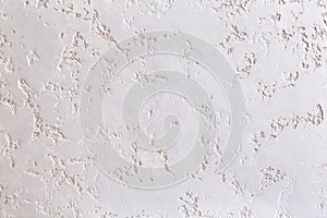 White plastered wall background with abstract pattern, close-up, macro.