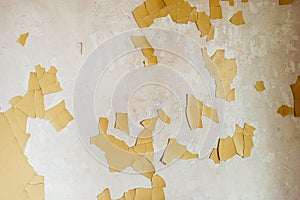 White plastered wall with cracked yellow paint.