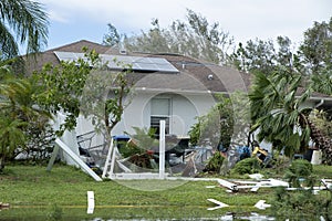 White plastic backyard fence damaged after hurricane winds in Florida. Aftermath of natural disaster