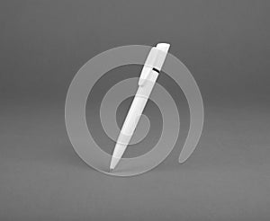 White plastic ballpoint pen on a grey backgroundÃÅ½