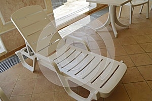 White plastic beach chair is inside the luxurious swimming pool