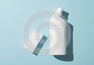 White plastic bottle and cap with shadow on blue isolated on white background
