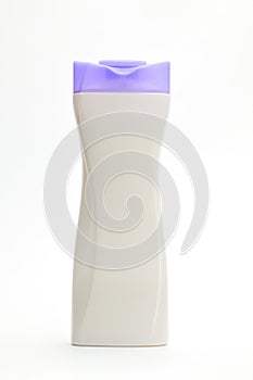 White plastic bottle for shampoo with a purple cap on a white background