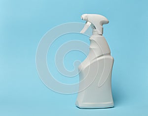 White plastic bottle with spray on a blue background, container for household chemicals