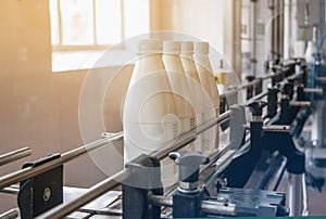 White plastic bottles with dairy product on the production line. Bottled on conveyor