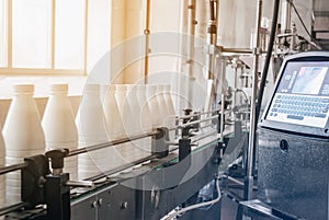 White plastic bottles with dairy product on the production line. Bottled on conveyor