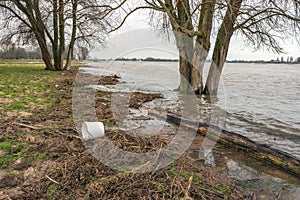 White plastic bucket washed ashore on the riverbank