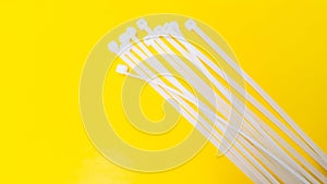 White plastic cable ties isolated on yellow background