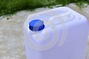 White plastic canister with blue lid in different positions