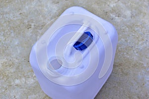 White plastic canister with blue lid in different positions