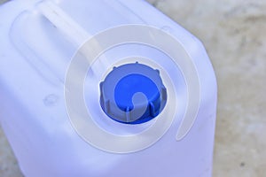 White plastic canister with blue lid in different positions