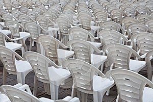 White plastic chairs in row stand waiting for visitors