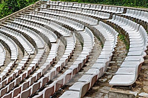 White plastic chairs in rows at outdoor stadium