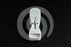 White plastic cloth clip isolated on black background