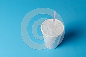 White plastic cup isolated on blue background.