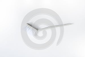 White plastic dish brush with gray handle on white background . Item for cleaning in kitchen
