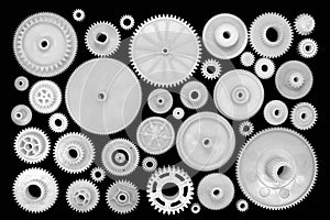 White plastic gears and cogwheels on black background