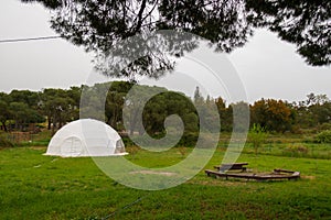 White plastic geodesic dome in a green field. Modern ball structure ball shaped