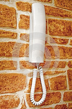 white plastic house intercom on the brick wall