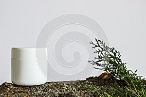 White plastic jars of creams on a light white background and tree bark. For cosmetics or cosmetology background. stand for adverti