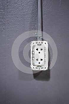 White plastic plug socket connected with silver metal pipe in vertical for electricity outlet