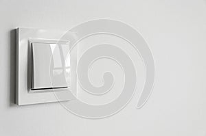 A white plastic power switch in an apartment on a white wall