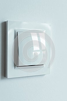 A white plastic power switch in an apartment on a white wall