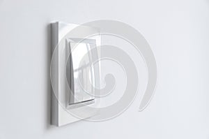 A white plastic power switch in an apartment on a white wall