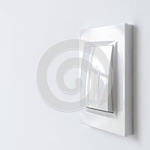 A white plastic power switch in an apartment on a white wall