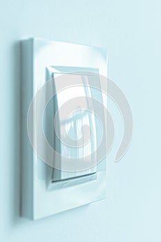 A white plastic power switch in an apartment on a white wall
